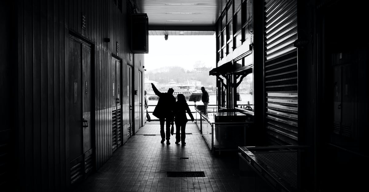 Relationship between NORG and Martine - Couple silhouettes walking on narrow passage of modern building