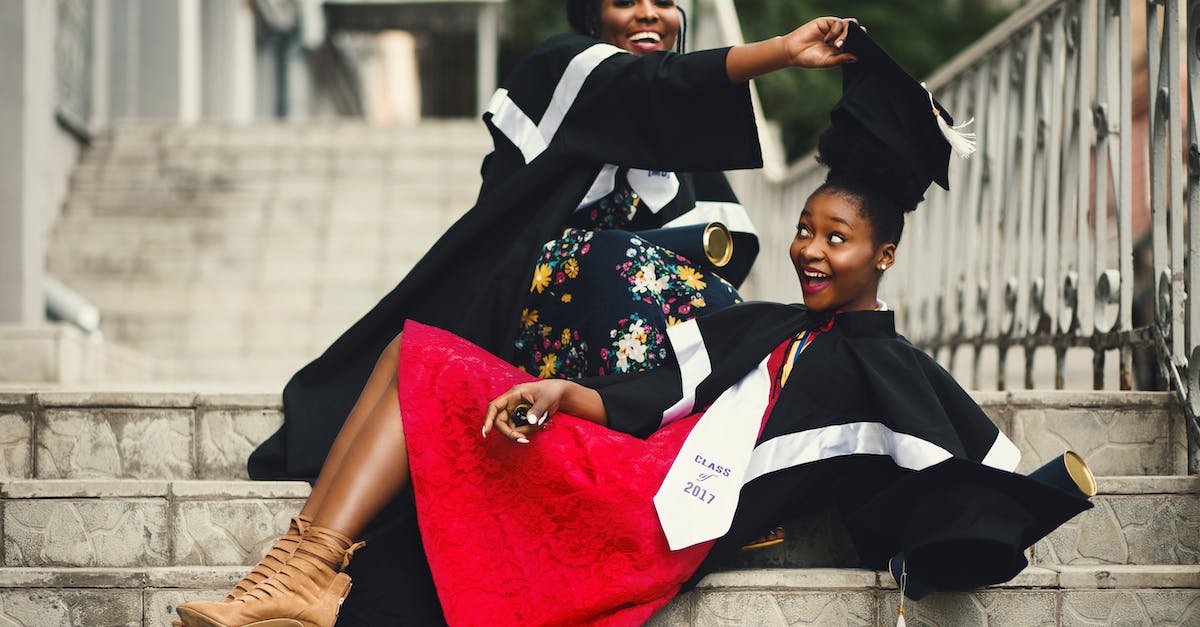 Removing Adventurers - Shallow Focus Photography of Two Women in Academic Dress on Flight of Stairs Removing Adventurers - Shallow Focus Photography of Two Women in Academic Dress on Flight of Stairs
