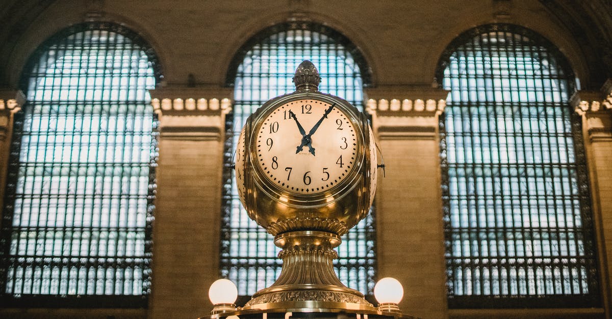 Removing durability one unit at a time - From below of aged retro golden clock placed atop information booth of historic Grand Central Terminal with arched windows Removing durability one unit at a time - From below of aged retro golden clock placed atop information booth of historic Grand Central Terminal with arched windows