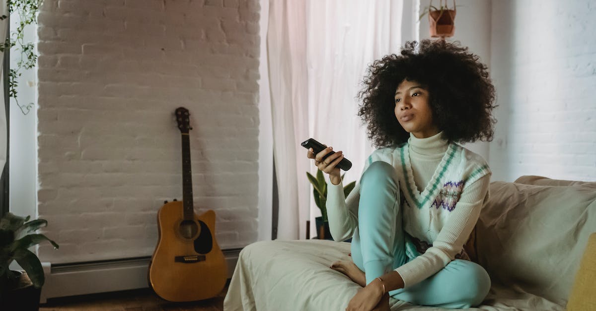 Replays - Switch YouTube account that movies are uploaded to? - Young black lady resting on sofa and watching TV at home
