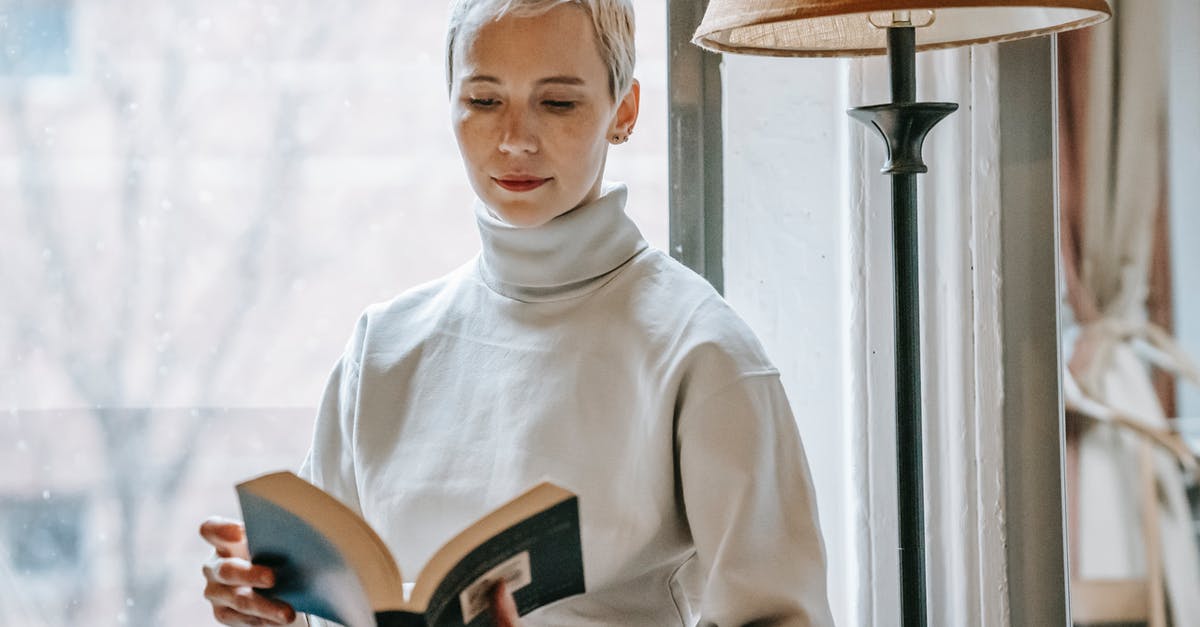 Research Ahead of Time - Woman with opened interesting book near lamp