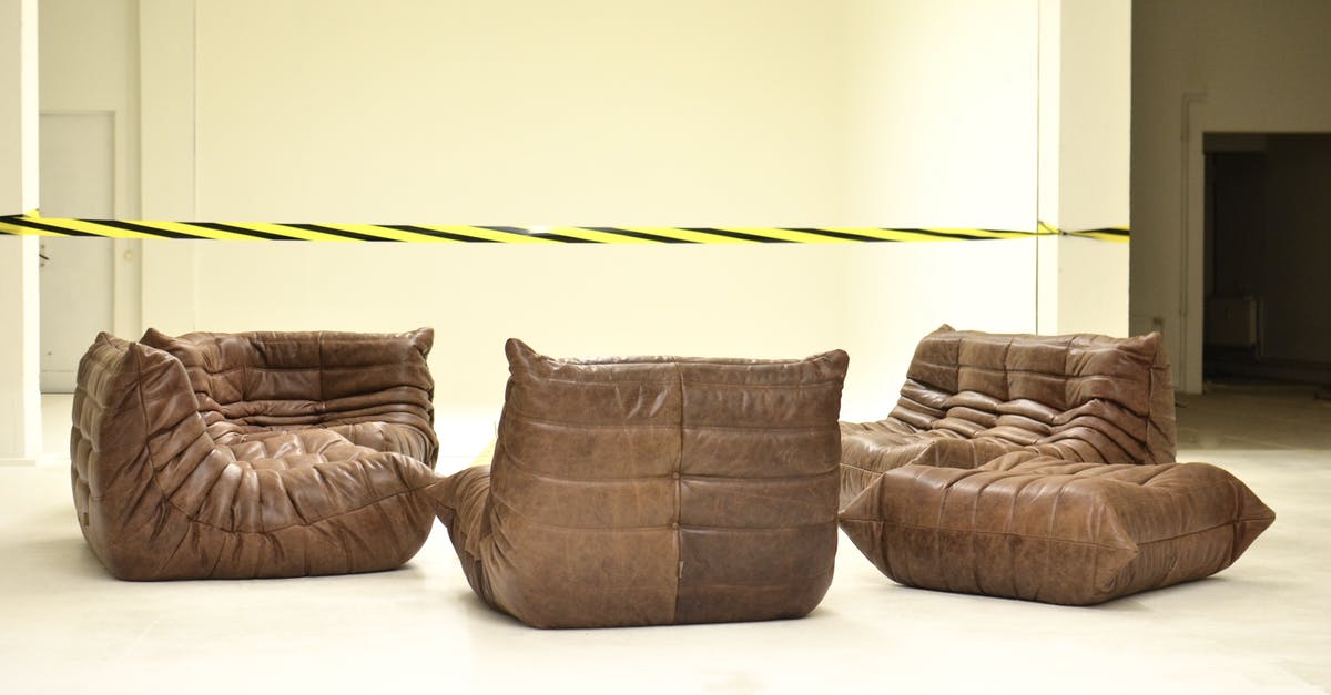 Restrict access to certain actions in certain areas? - Leather couches placed in empty room under bright striped barrier tape during renovation process