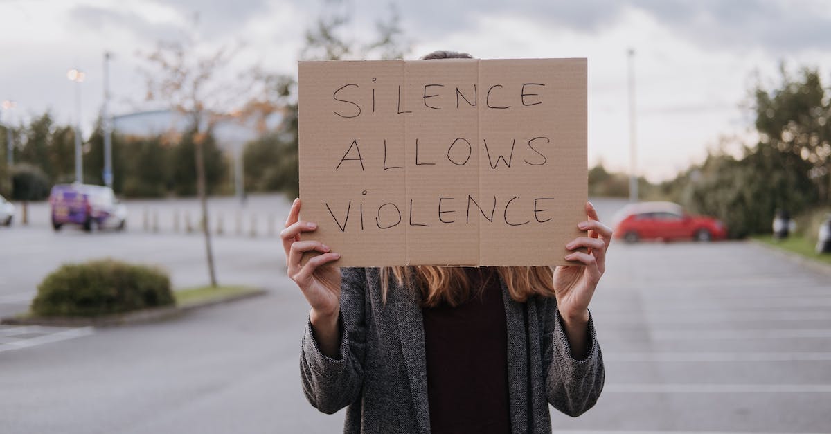 Riki's Blink Strike against Faceless Void's Chronosphere - Unrecognizable woman in casual clothes standing on road and demonstrating poster Silence Allows Violence