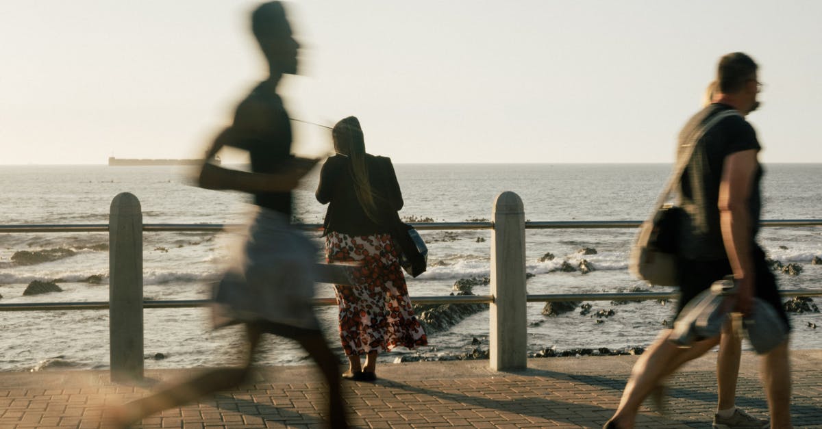 Run Sonic Heroes on modern graphics - People in casual clothes walking and running on embankment while woman resting on waterfront and looking on waves during evening on resort Run Sonic Heroes on modern graphics - People in casual clothes walking and running on embankment while woman resting on waterfront and looking on waves during evening on resort