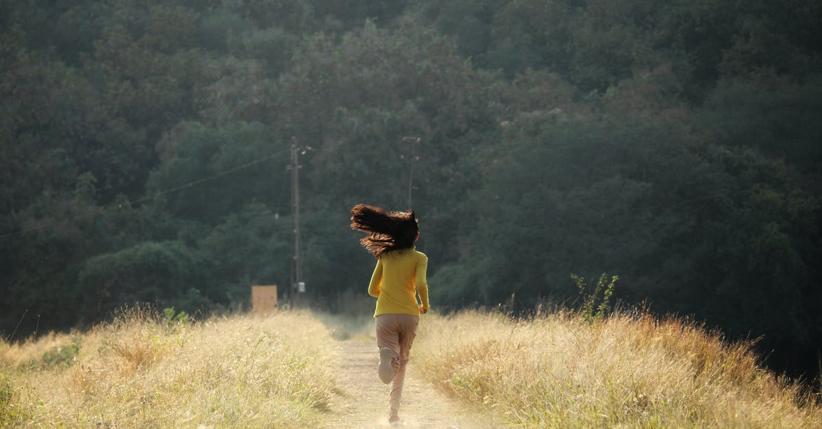Running Forward vs. Backwards and Escaping Attack - Back View of Woman Running on Footpath in Meadow with Tousled Hair Running Forward vs. Backwards and Escaping Attack - Back View of Woman Running on Footpath in Meadow with Tousled Hair
