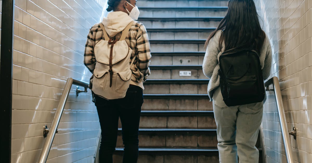 Safe way to remove marker from SNES cartridge - Back view of African American female in mask walking on stairway in subway passage during coronavirus pandemic