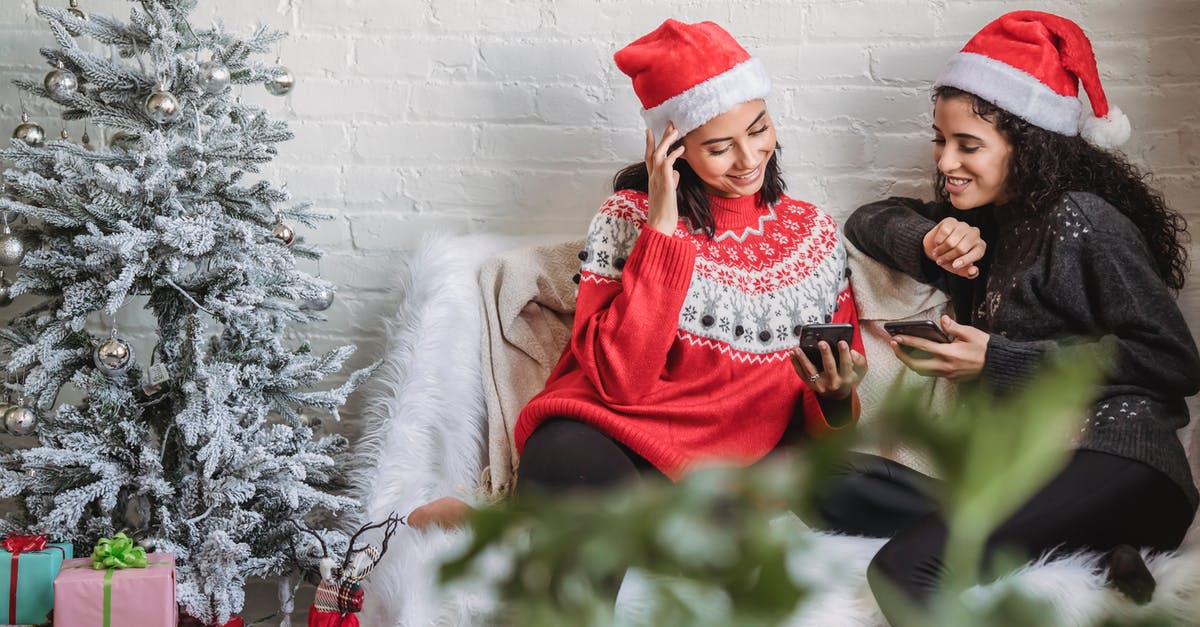 Safest Sister of Eve Level 4 Security Missions - Smiling young ethnic females in cozy sweaters and Santa hats browsing modern mobile phones while sitting on comfy sofa together near decorated Christmas tree Safest Sister of Eve Level 4 Security Missions - Smiling young ethnic females in cozy sweaters and Santa hats browsing modern mobile phones while sitting on comfy sofa together near decorated Christmas tree