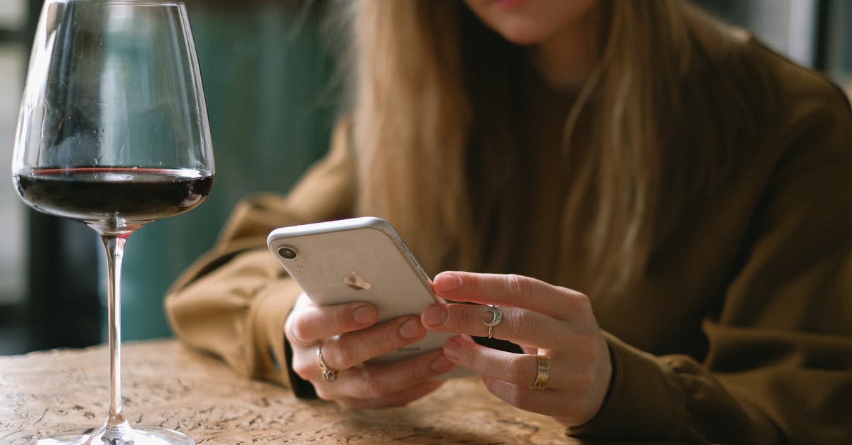 Scrolling malfunction - Woman Sitting with a Glass of Wine Scrolling Through Her Phone 