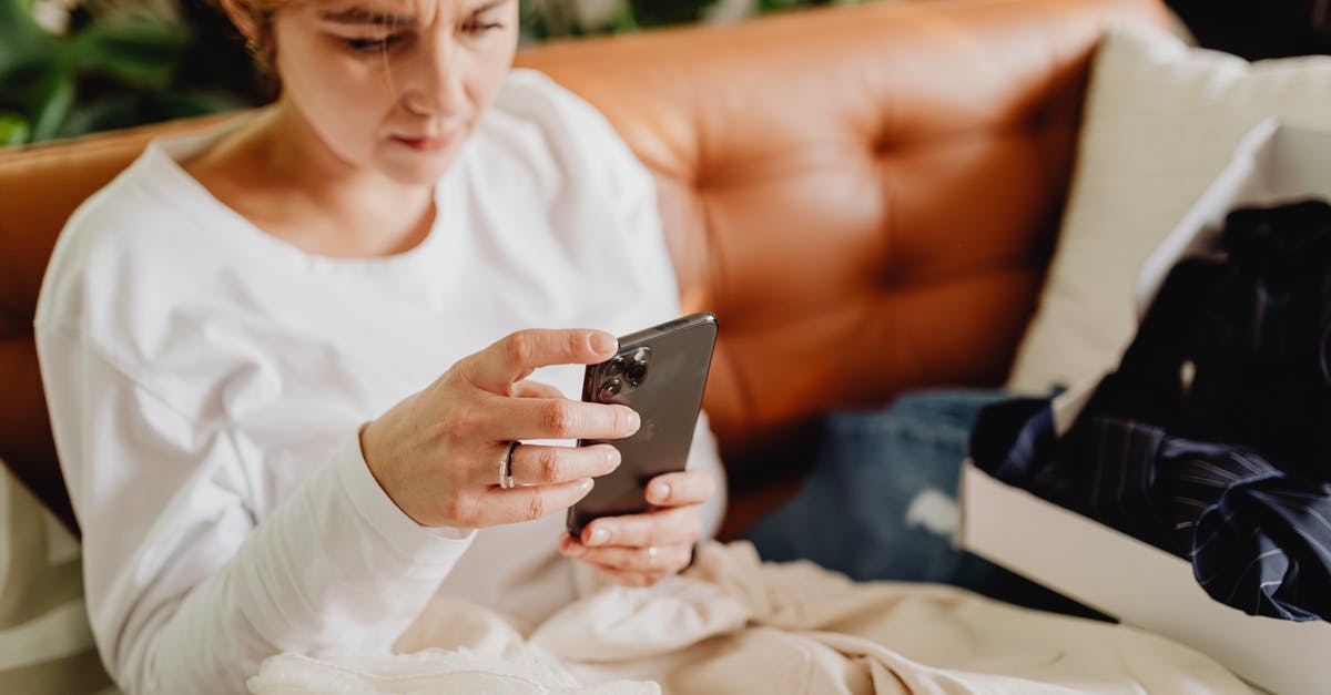 Scrolling malfunction - Woman Sitting on a Couch and Scrolling Through Her Phone Scrolling malfunction - Woman Sitting on a Couch and Scrolling Through Her Phone