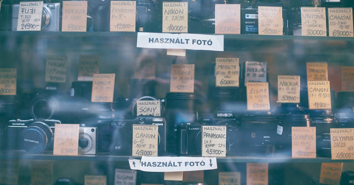 Set a tag on slots/hotbars - Through glass collection of various photo cameras placed on local store showcase with paper price label and inscriptions Set a tag on slots/hotbars - Through glass collection of various photo cameras placed on local store showcase with paper price label and inscriptions