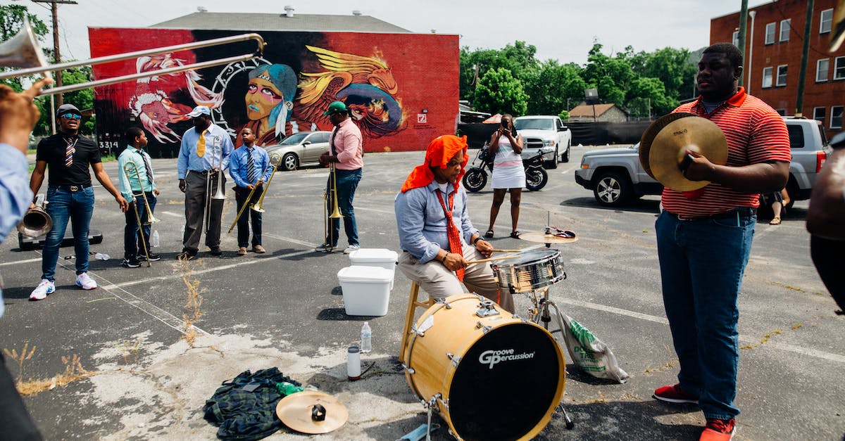Setting up local Minecraft for multiple player - Group of anonymous African American people in casual clothes playing musical instruments on street near audience Setting up local Minecraft for multiple player - Group of anonymous African American people in casual clothes playing musical instruments on street near audience