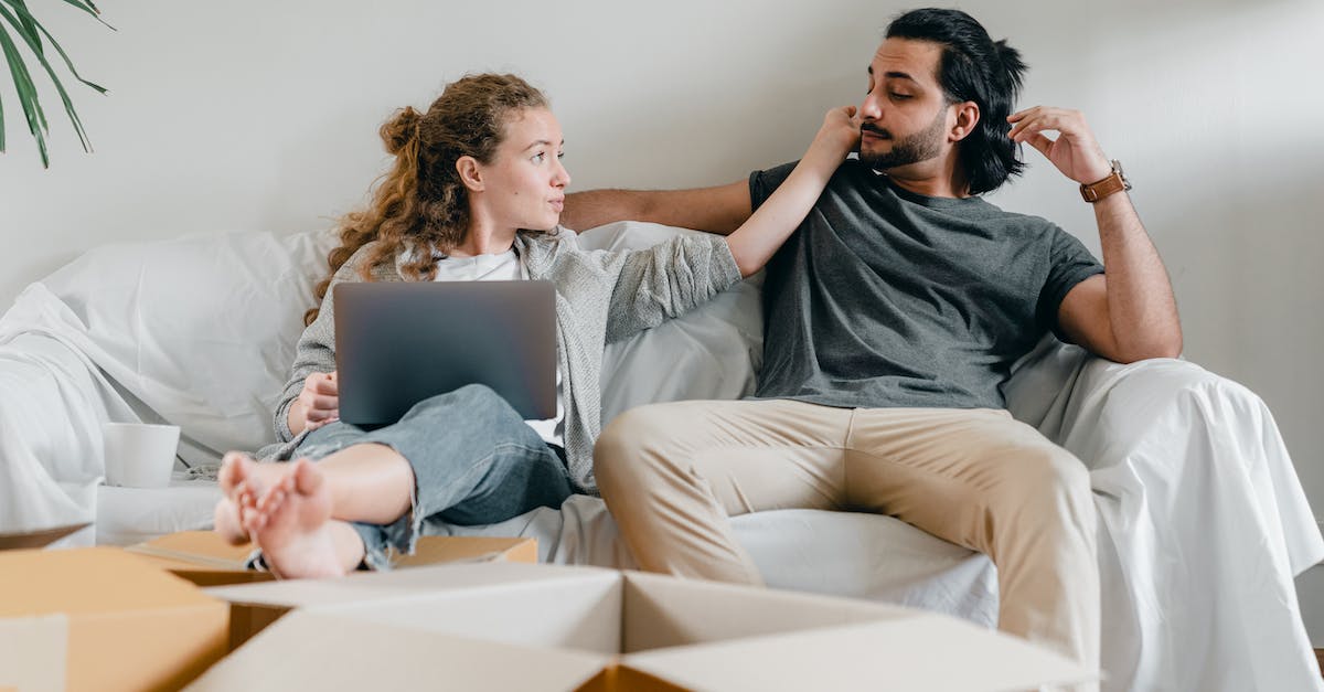 Share toy box with other local user profiles - Girlfriend with laptop touching ethnic face of man on sofa Share toy box with other local user profiles - Girlfriend with laptop touching ethnic face of man on sofa