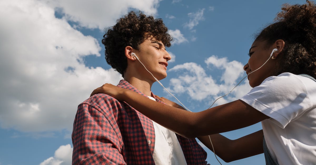Sharing Finds in No Man's Sky - Teenage couple sharing headphones against blue sky