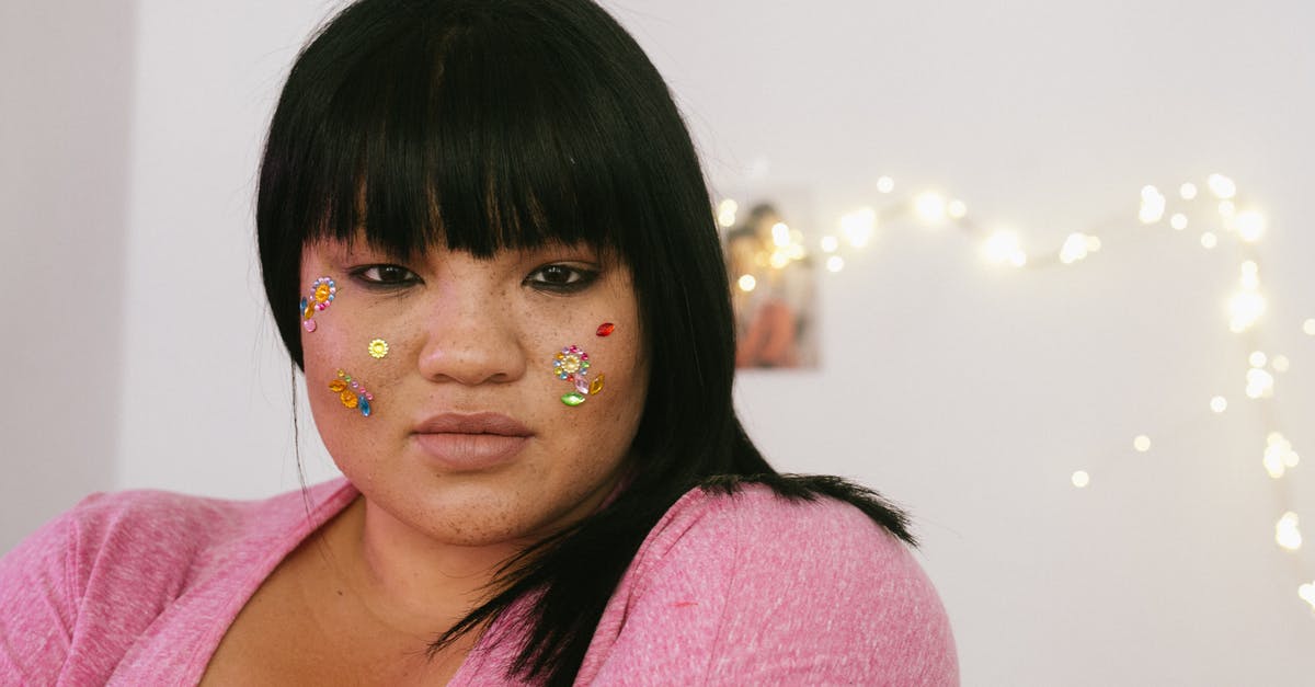 Should I accept an enemy retreat? - Tender young ethnic overweight lady with black hair and colourful glitter on face wearing pink shirt standing in light decorated room and looking at camera Should I accept an enemy retreat? - Tender young ethnic overweight lady with black hair and colourful glitter on face wearing pink shirt standing in light decorated room and looking at camera