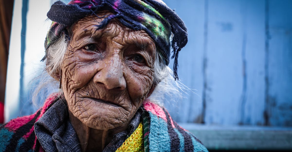 Should I be advancing to the next Age/Level of units immediately or max out on the current Age first? - Senior wrinkly ethnic woman in headscarf near shabby building