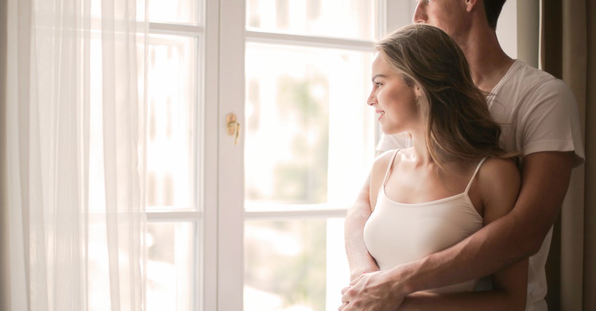 Should I evolve now or wait for a higher I.V. percentage? [closed] - Side view of content young couple in casual clothes standing and hugging while enjoying weekend and looking out of window together