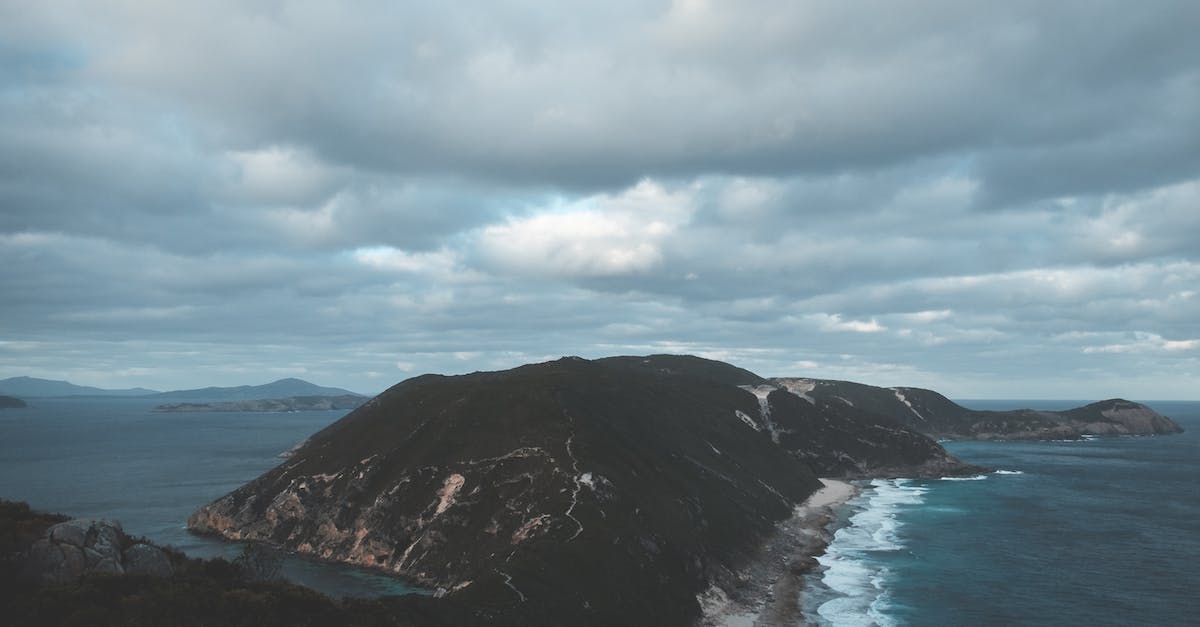 Should I mantain Cloning Bay powered when traveling? - Breathtaking scenery of dramatic cloudy sky over Bald Head walking track and Isthmus Hill surrounded by foamy stormy ocean with sandy beach