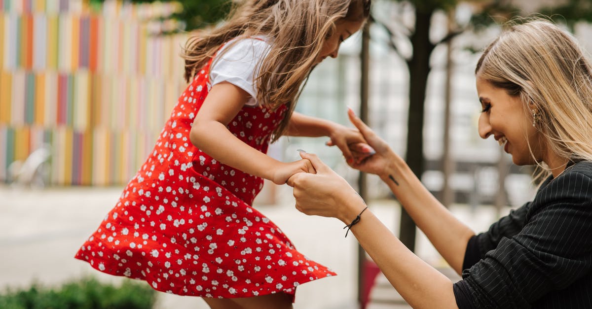 Should I play Maniac Mansion before Day of the Tentacle? - Side view of smiling woman supporting girl while spending time together on playground in summer day on street
