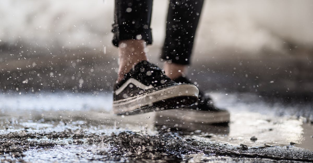 Should I spray or fertilize my crops? - Crop person walking through puddles on asphalt