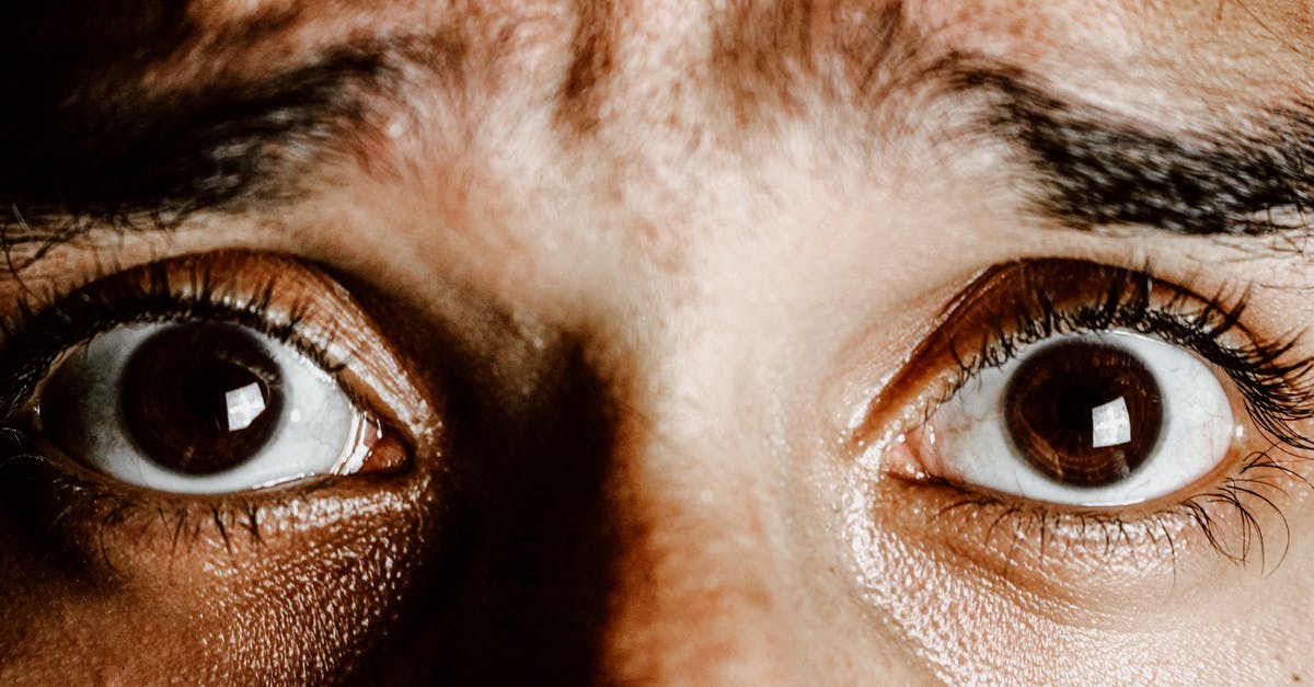 Should I to go the Nightmare Frontier? - Crop face of person with brown eyes with fear on face looking at camera Should I to go the Nightmare Frontier? - Crop face of person with brown eyes with fear on face looking at camera