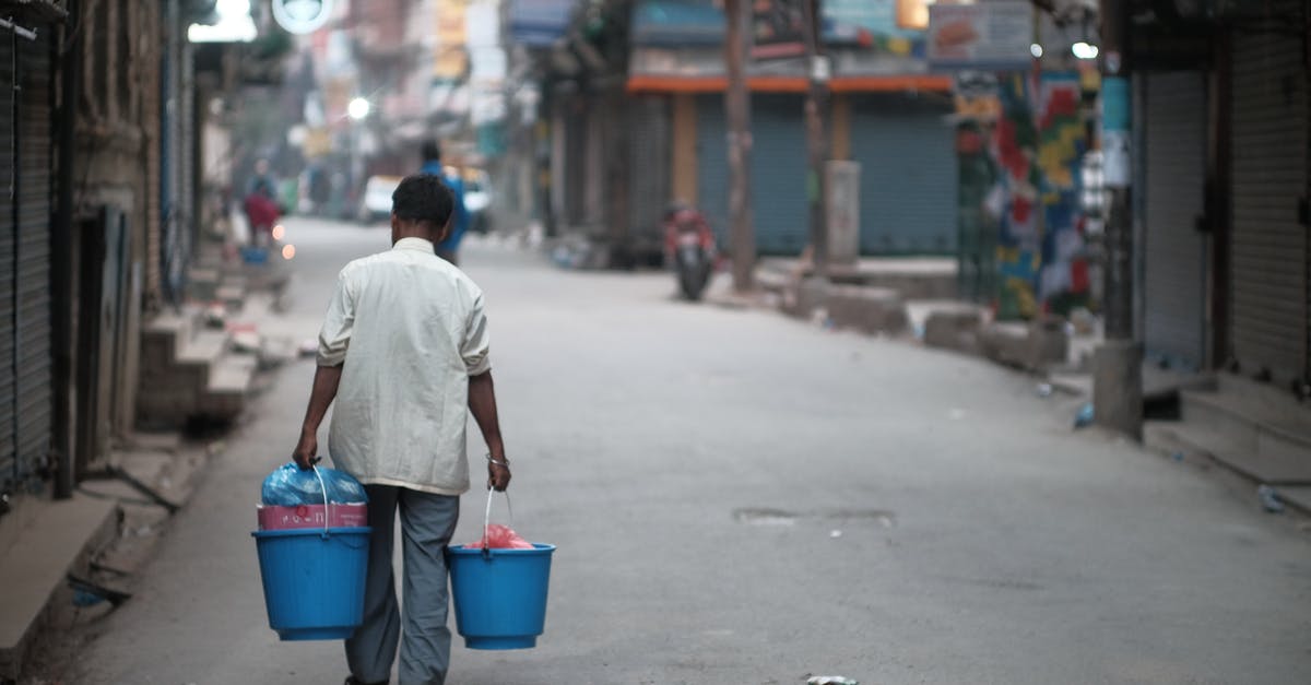 Should I turn OFF full Cemeteries - Man Carrying Two Full Buckets Through a City Street Should I turn OFF full Cemeteries - Man Carrying Two Full Buckets Through a City Street