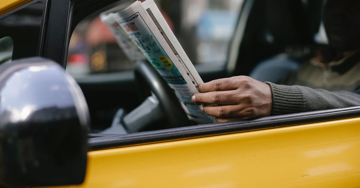 Should I wait until post-game to read Secret Reports? - Side view of crop anonymous ethnc male driver reading information in newspaper article while waiting for client Should I wait until post-game to read Secret Reports? - Side view of crop anonymous ethnc male driver reading information in newspaper article while waiting for client