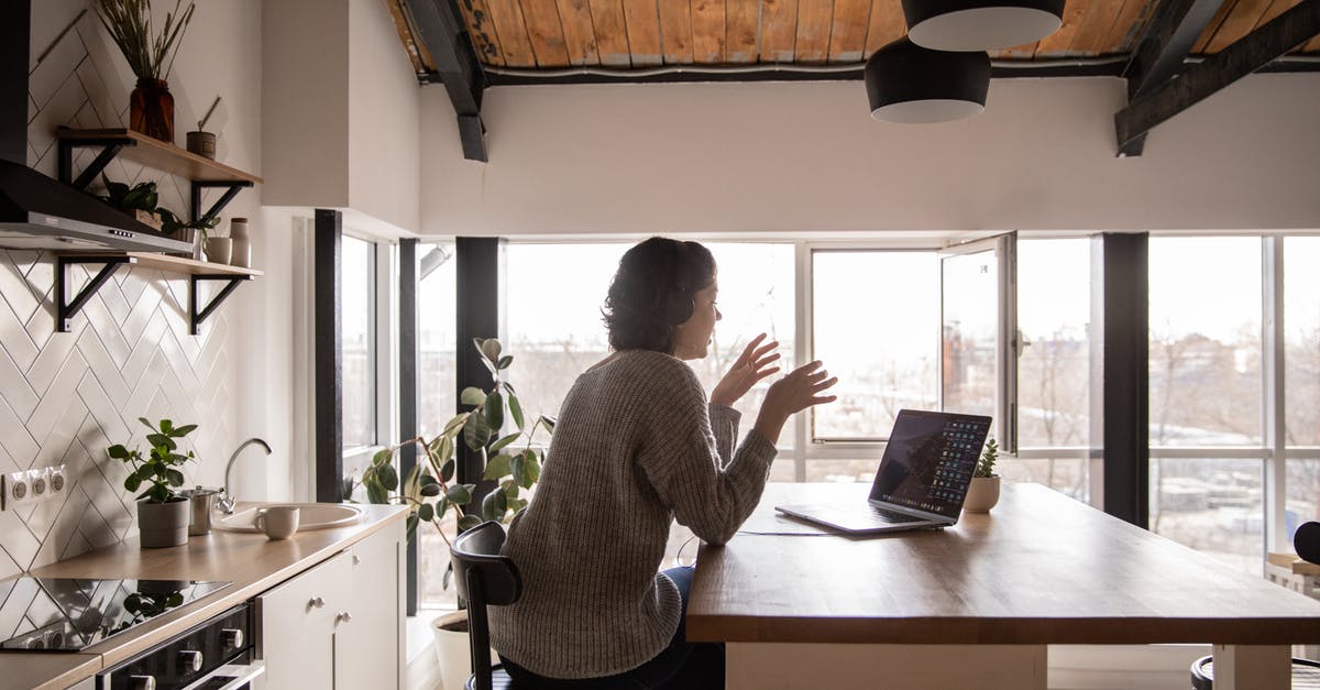 Silent Hill 4: The room crashes after I enter first portal back to the apartment. I am using Widescreen fix - Back view of young female expressively talking via laptop while sitting at wooden table in spacious kitchen