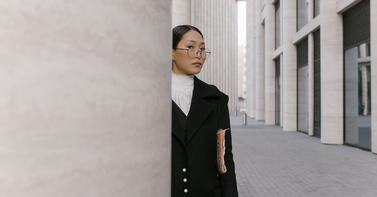 Silverfish stone/egg placement - Woman in Black Coat Standing Near White Wall Silverfish stone/egg placement - Woman in Black Coat Standing Near White Wall