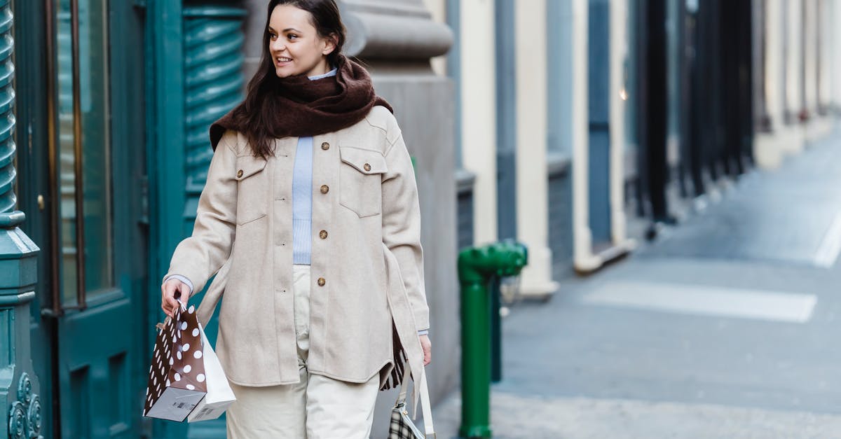 Simcity-buildit: Where do gifts appear in neighboring cities - Confident young female shopper strolling on city street with gift bags Simcity-buildit: Where do gifts appear in neighboring cities - Confident young female shopper strolling on city street with gift bags