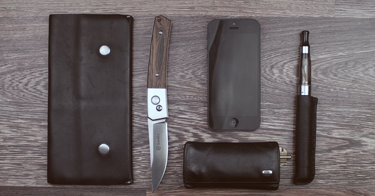 skins by unlocking cases CSGO - Brown Knife, Black Iphone 5 and Black Vaporizer Pen on Brown Wooden Surface