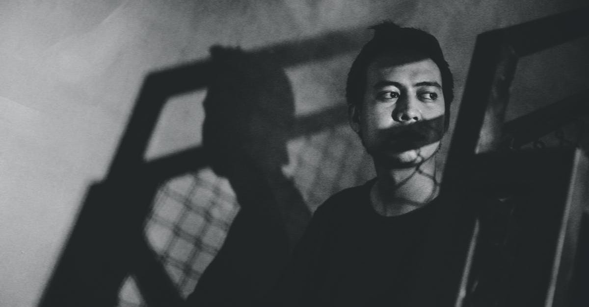 Skyrim Character Creation Problem - Black and white depressed ethnic guy with shadow on face looking away while sitting on stairs in grungy room