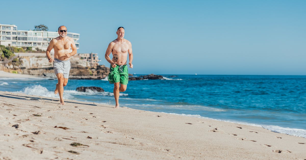 Skyrim Dragons Running When Hurt? - Man in Green Shorts Standing Beside Woman in Blue and Green Floral Bikini on Beach during