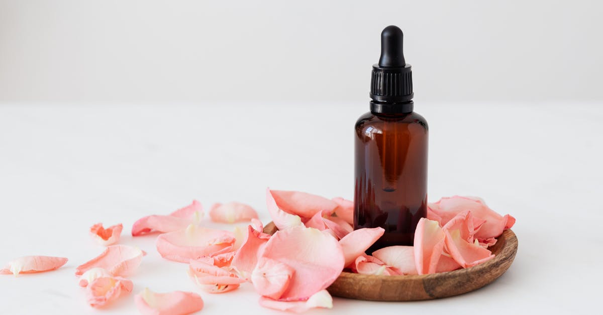 Small White Soapstone vs. White Soapstone - Gentle pale pink wavy rose petals placed on small round wooden plate and table near dark glass essence flask on white background Small White Soapstone vs. White Soapstone - Gentle pale pink wavy rose petals placed on small round wooden plate and table near dark glass essence flask on white background