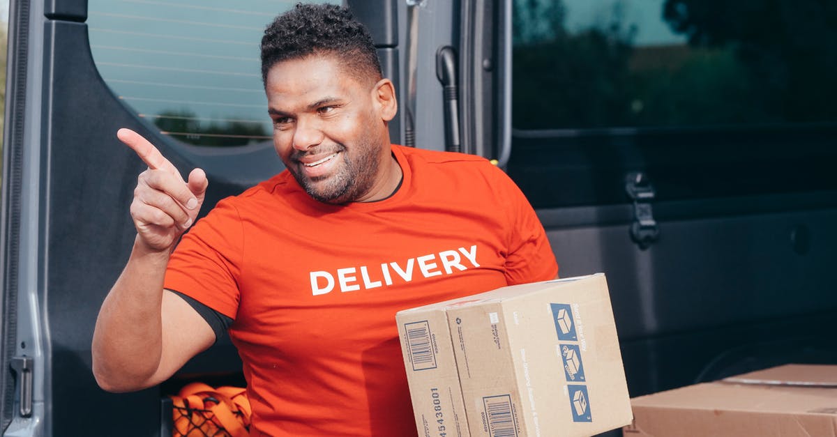 Sneaking away from a box delivery point - Man in Red Crew Neck T-shirt Holding White Box Sneaking away from a box delivery point - Man in Red Crew Neck T-shirt Holding White Box