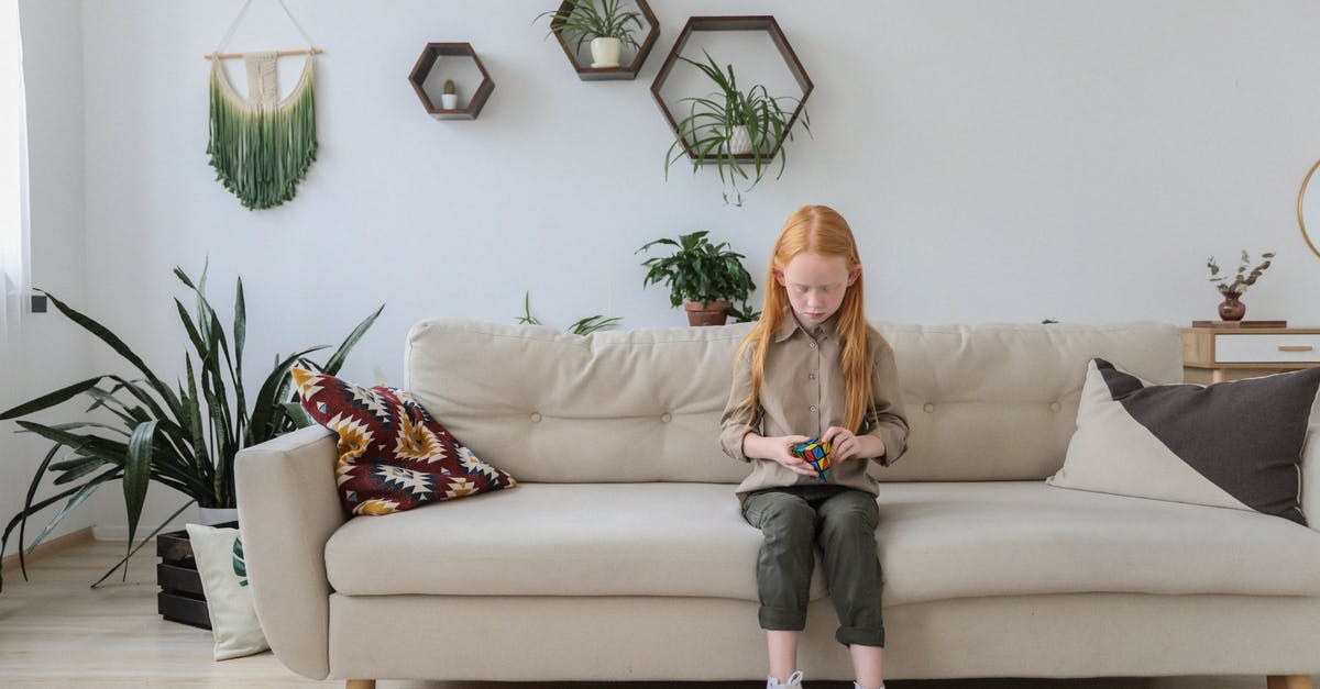 Sofa blocking puzzle [duplicate] - Serious girl in fashionable clothes solving puzzle and sitting on cozy sofa with bright cushion in contemporary lounge