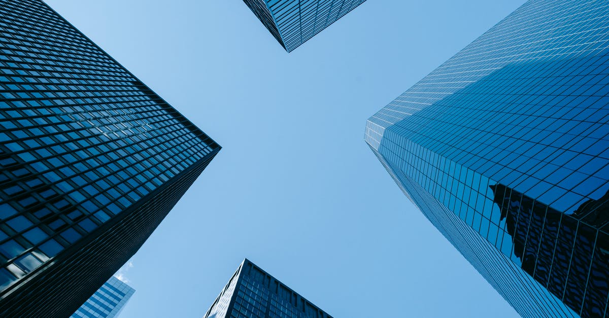 Songs developing a lag as they progress - Low angle of high business towers with glass mirrored windows located in megalopolis downtown against blue sky