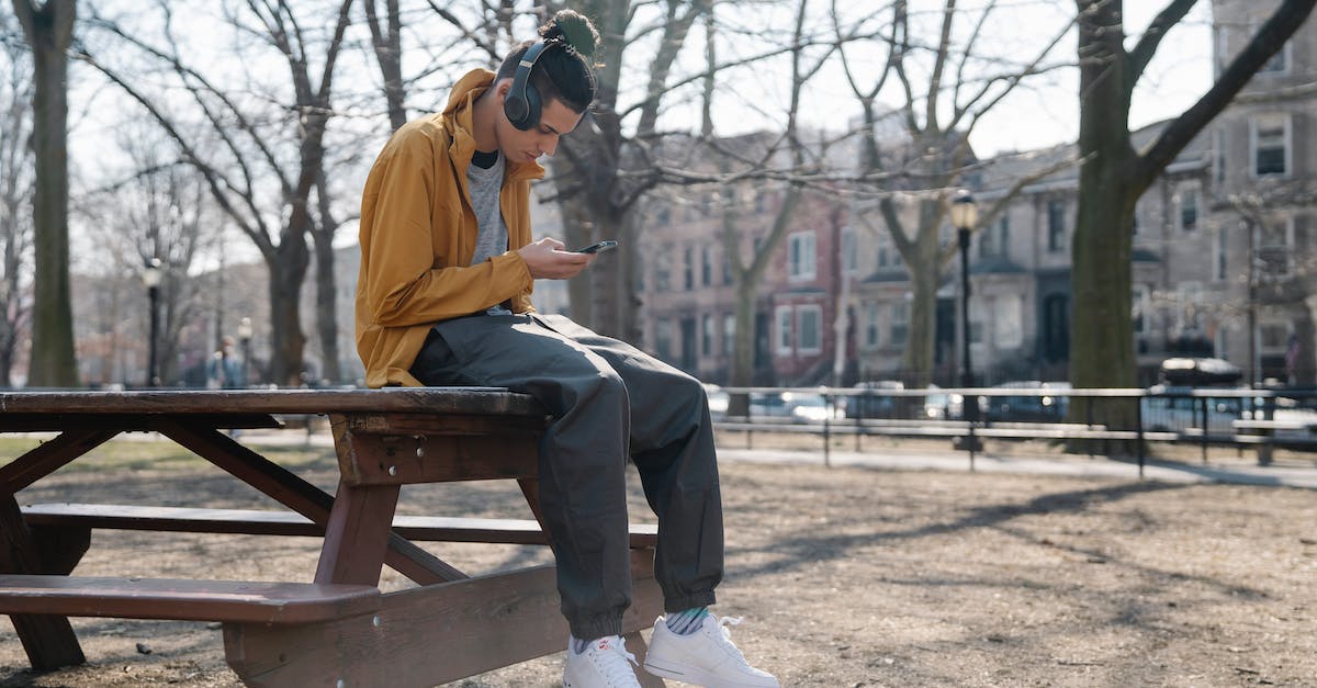 Sound does not come on Headphones in Watch Dogs - Cool ethnic male in headphones text messaging on cellphone while listening to music and sitting on table in town Sound does not come on Headphones in Watch Dogs - Cool ethnic male in headphones text messaging on cellphone while listening to music and sitting on table in town
