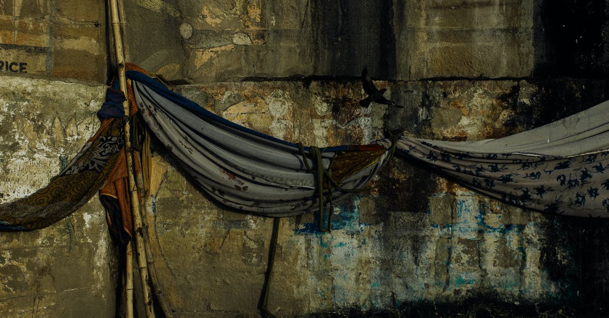 Spinning the stick minigames - How to not destroy my palms? - Fabric hammocks hanging on bamboo stick against aged damaged weathered wall of embankment