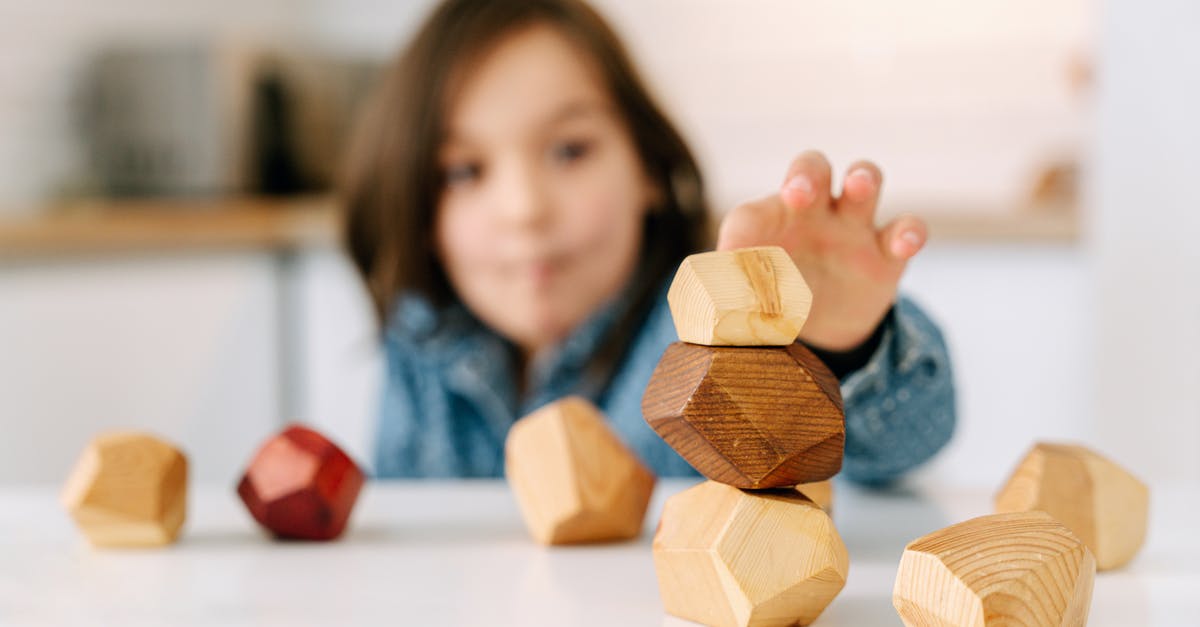 stacking up op enchantments on a sword? [duplicate] - Shallow Focus Photo of a Kid Playing Wooden Blocks