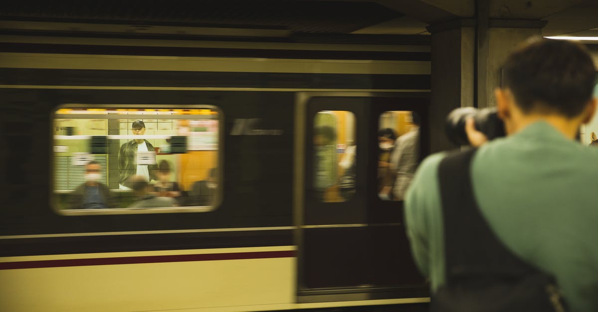 Stations with orbit making move too fast - Photographer with modern device taking photo of train with passengers Stations with orbit making move too fast - Photographer with modern device taking photo of train with passengers