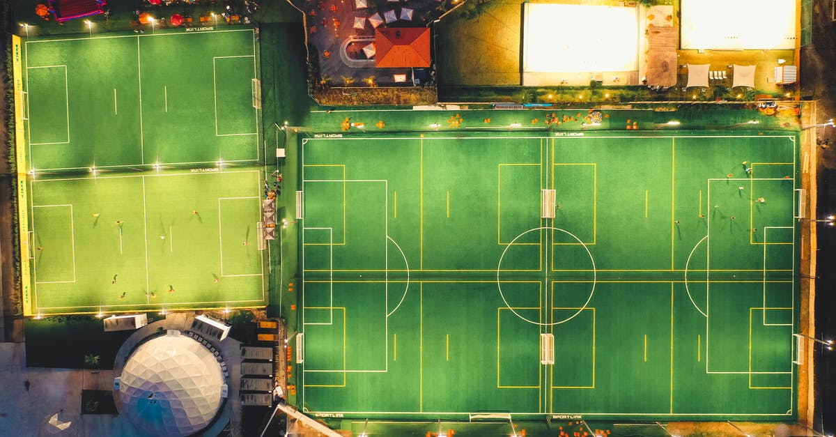 Steam - location and game censorship - Drone top view of empty football fields in modern city area illuminated at night Steam - location and game censorship - Drone top view of empty football fields in modern city area illuminated at night