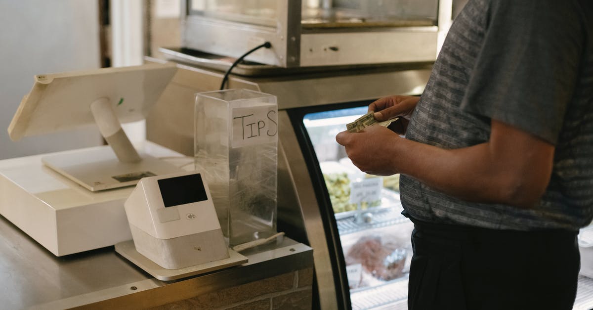Steam Market buy order functionality - Unrecognizable male in casual clothes standing with money near cash register in grocery store while making purchase near glass showcase