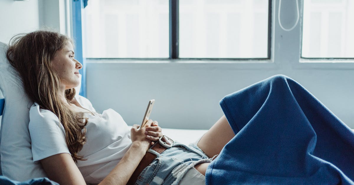 Steam mobile authenticator on a Windows phone - Woman Lying in Bed, Holding a Phone and Looking Out the Window 