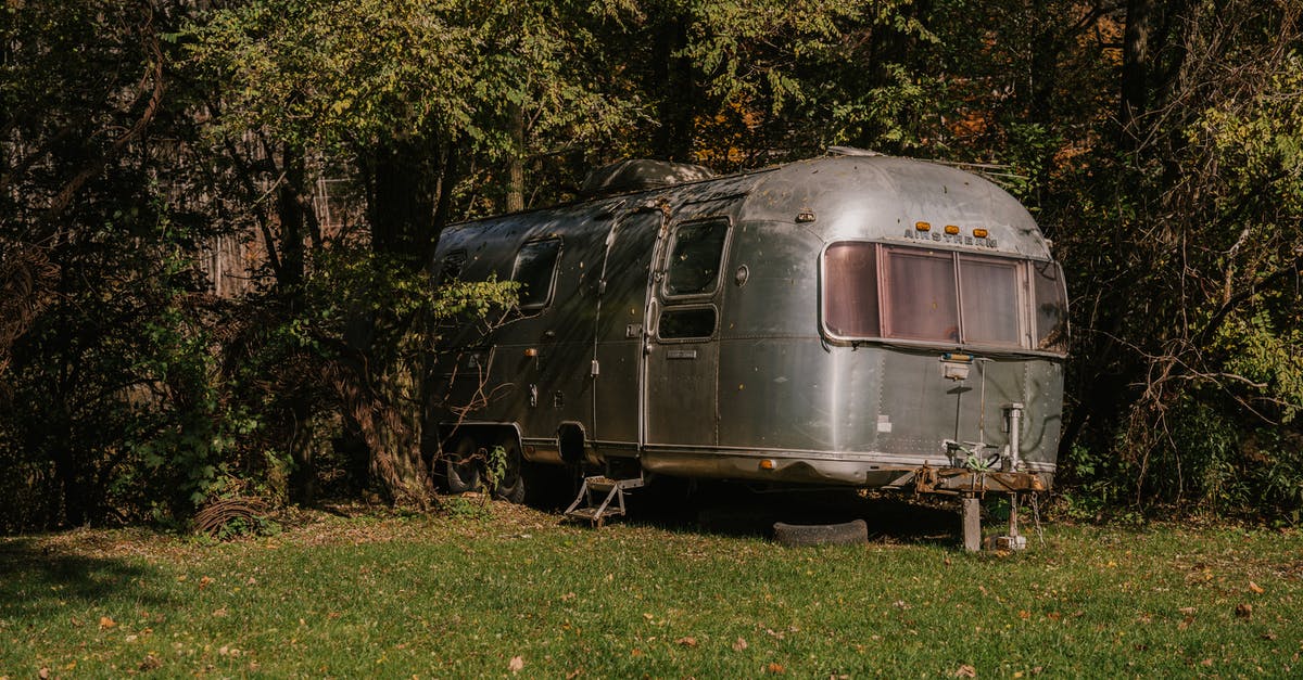 Stop Camera Rotation During Wild Battle - Old fashioned motor house stopped in green forest for people having rest at weekend Stop Camera Rotation During Wild Battle - Old fashioned motor house stopped in green forest for people having rest at weekend
