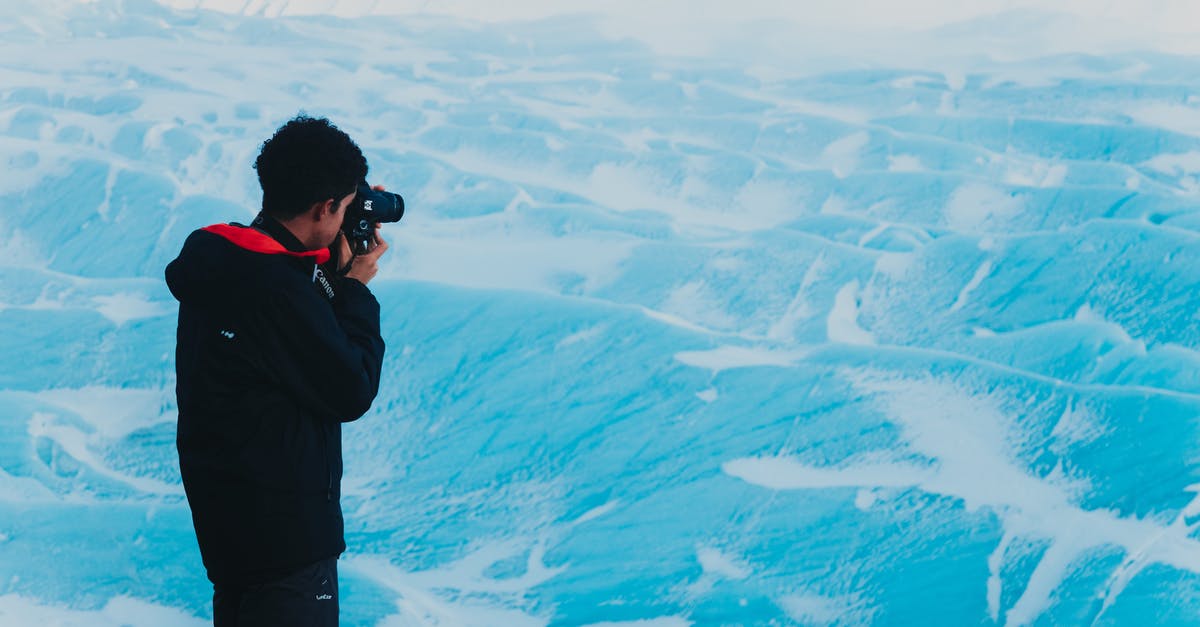 Stop Camera Rotation During Wild Battle - Man taking photo of snowy mountainous terrain Stop Camera Rotation During Wild Battle - Man taking photo of snowy mountainous terrain