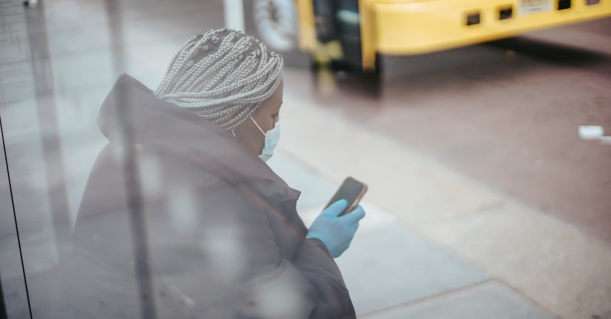 Stop Minecraft Ticks when zero players online - Through glass wall side view of African American female doctor using cellphone on pavement against bus on urban road