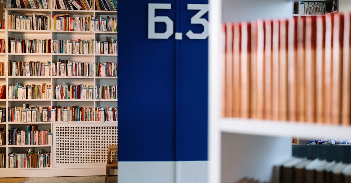Storing books in the Arcaneum library - Books on White Wooden Shelf Storing books in the Arcaneum library - Books on White Wooden Shelf