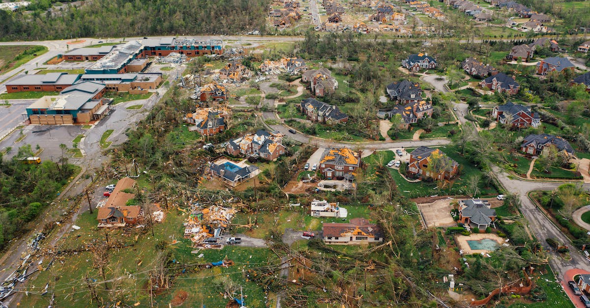 Storm Crow 'fiery ball' damage - Aerial view of tornado impact on small settlement cottages with destroyed roofs windthrown trees and bent electricity transmission lines