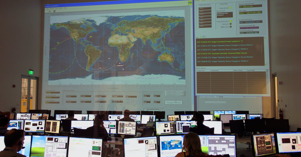 Strategy for reaching Wave 30 on Modern Warfare 3's survival map 'Resistance'? - Back view of unrecognizable employees working on computers in flight control room with big interactive map on wall and analyzing data