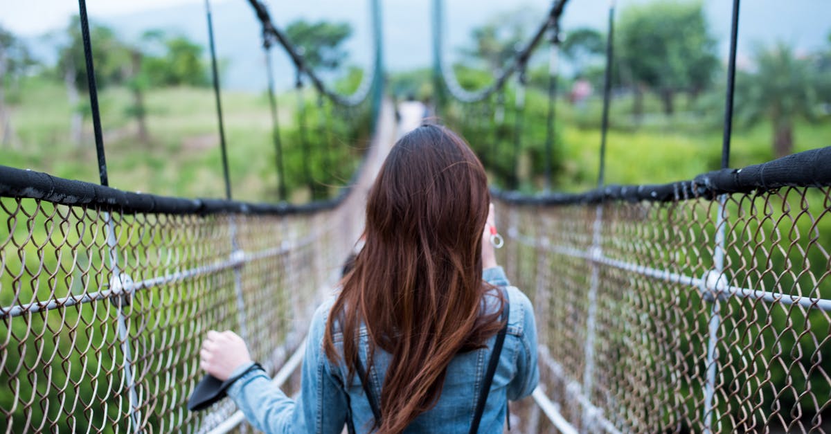Stuck at swing bridge in Hunrath - Woman in Blue Long-sleeved Dress on Rope Bridge